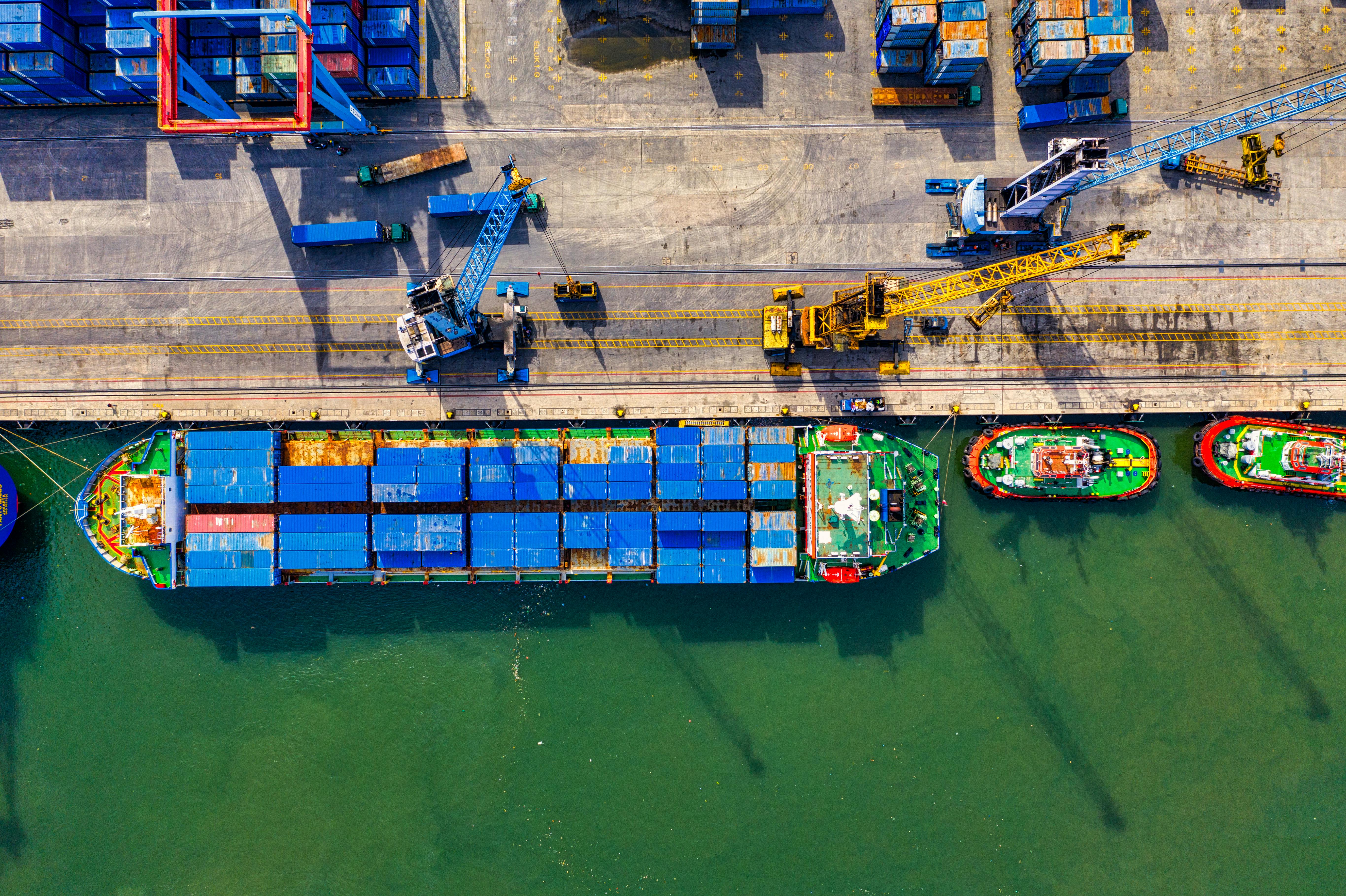 Top-down port operation with vessel, cranes, containers, and tug support